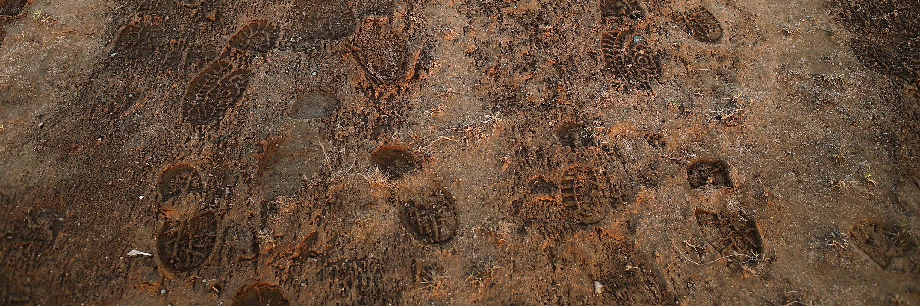 Prints left in the mud by someone wearing hiking boots.