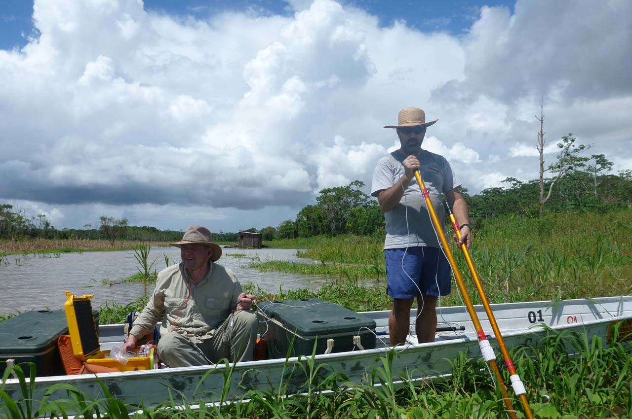 two men in a boat performing an experiment