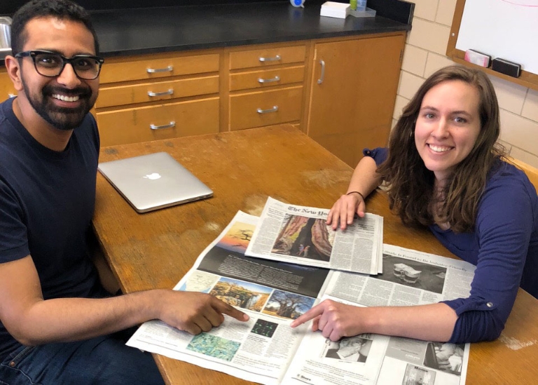 Courtney Ellison (right) and Ankur Dalia point to the article about their research printed in The New York Times on June 19, 2018.