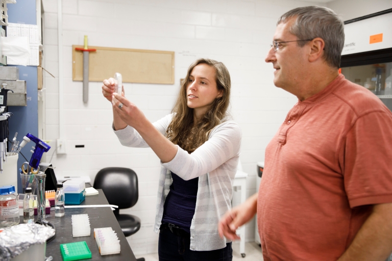 IU Ph.D. student Courtney Ellison (left) examines a sample in the lab with Yves Brun, IU Distinguished Professor of Biology. 2018.