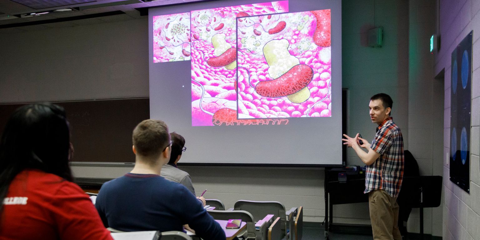Professor Jake McKinlay using his artwork to teach his undergraduate course on microbial physiology.