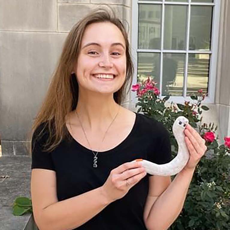 Emily Erdmann holds a replica of a nematode.