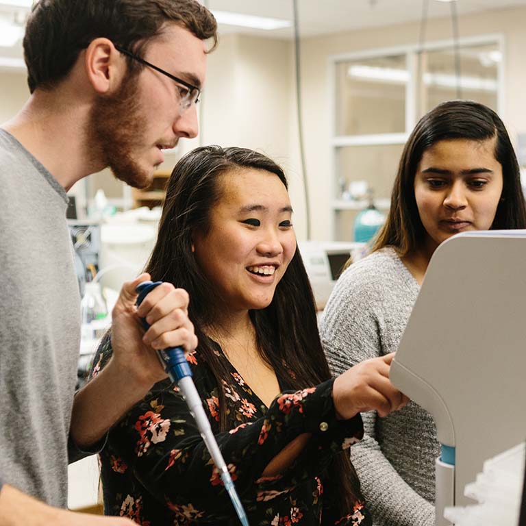 Three students working in a research lab.