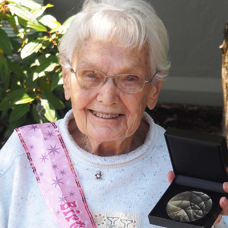 Alumna and retired IU Biology faculty member Ruth Dippell smiles as she holds up the IU Bicentennial Medal
awarded to her on her 100th birthday in June 2020.
