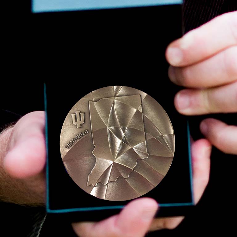 Craig Pikaard holds open the box to display the bronze IU Bicentennial Medal he was awarded.